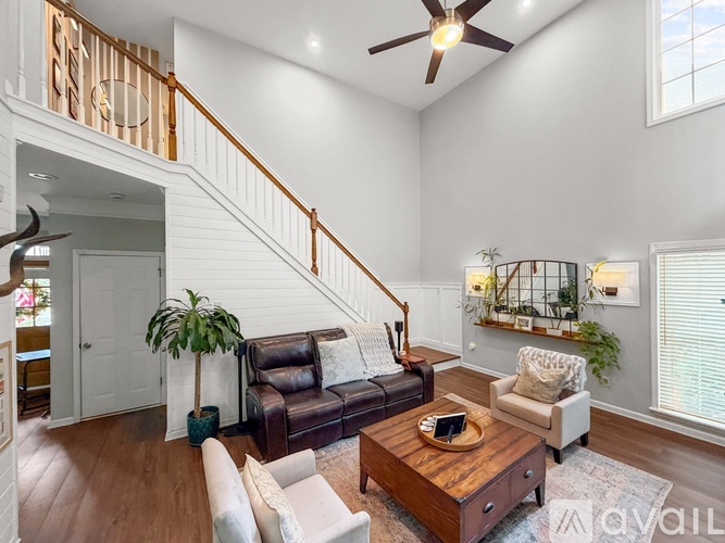 A living room with a brown leather couch and a wooden coffee table.