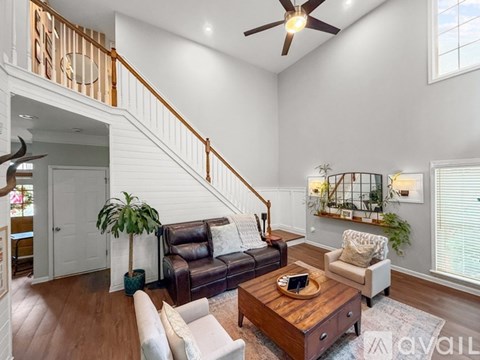 A living room with a brown leather couch and a wooden coffee table.