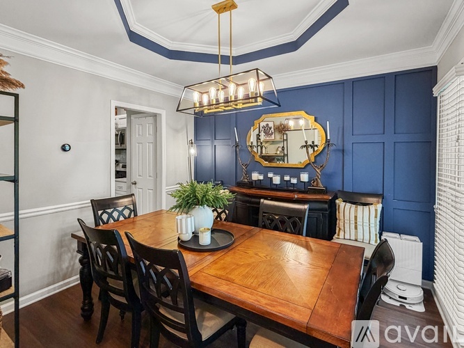 A dining room with a wooden table and chairs.