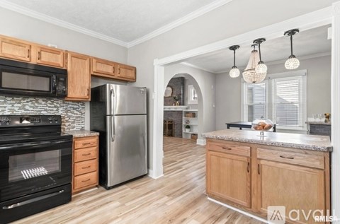 A kitchen with wooden cabinets and a black oven.