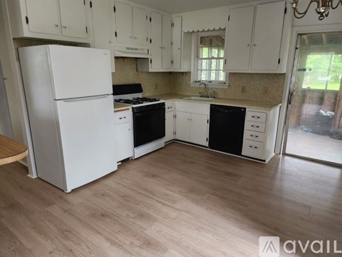A kitchen with white appliances and cabinets.