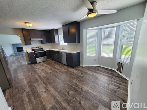 A kitchen with dark wood floors and a white ceiling.