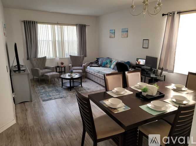 A living room with a dining table set for six.