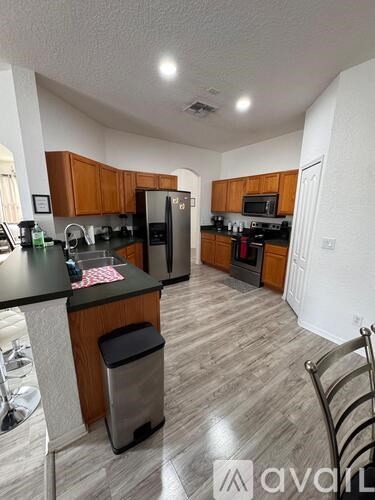 A kitchen with wooden cabinets and a black countertop.