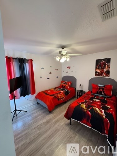 A bedroom with two beds and a ceiling fan.