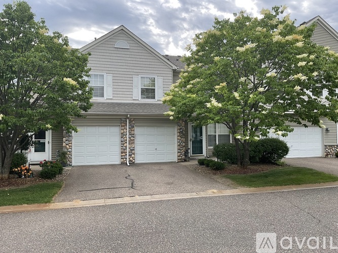 A two-story house with a garage and a driveway.