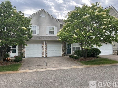 A two-story house with a garage and a driveway.