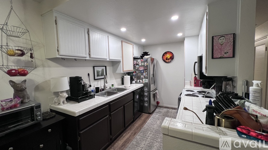 A kitchen with white cabinets and a white counter top.
