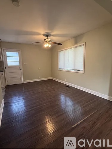A room with a ceiling fan and wooden flooring.
