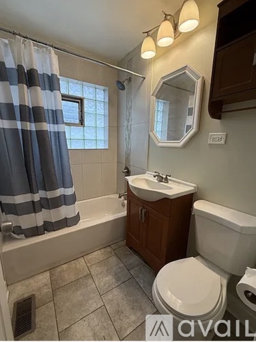 A bathroom with a toilet, sink, and shower.
