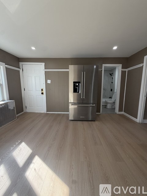 A kitchen with a refrigerator, sink, and cabinets.