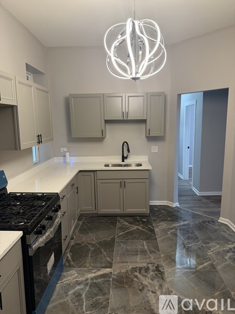 A kitchen with marble flooring and a black stove top.
