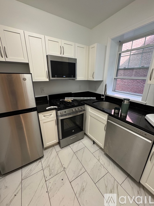 A kitchen with white cabinets and stainless steel appliances.