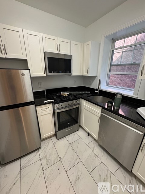 A kitchen with white cabinets and stainless steel appliances.