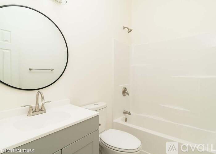 A bathroom with a toilet, sink, and mirror.