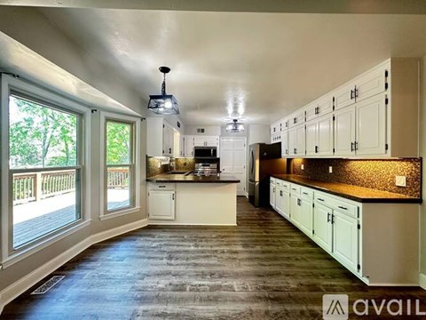 A kitchen with white cabinets and a black countertop.