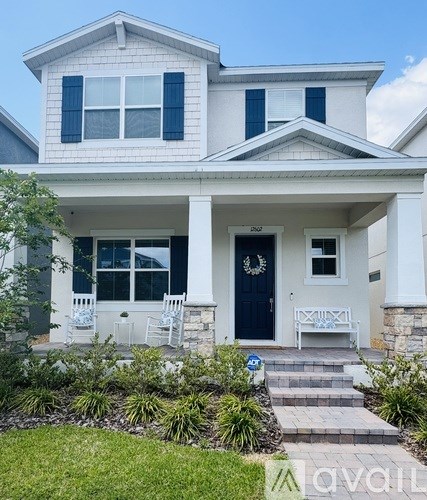 A white house with a black front door and a small porch.