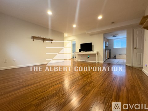 A living room with a television and a wooden floor.
