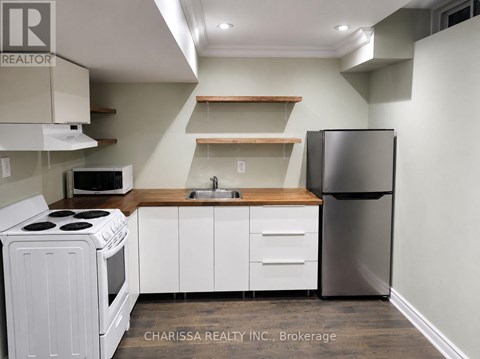 A kitchen with white appliances and wooden shelves.