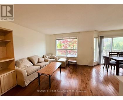 A living room with a couch, chairs, and a dining table.