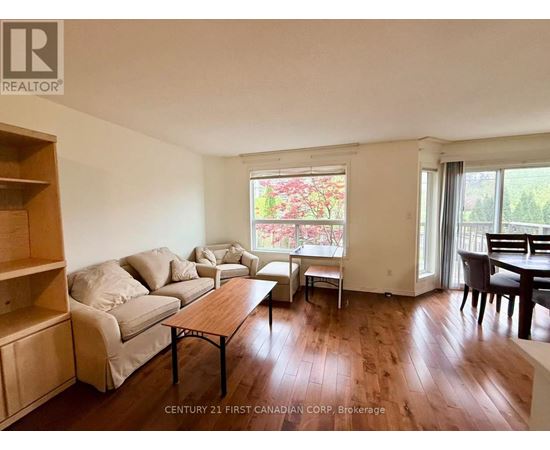 A living room with a couch, chairs, and a dining table.