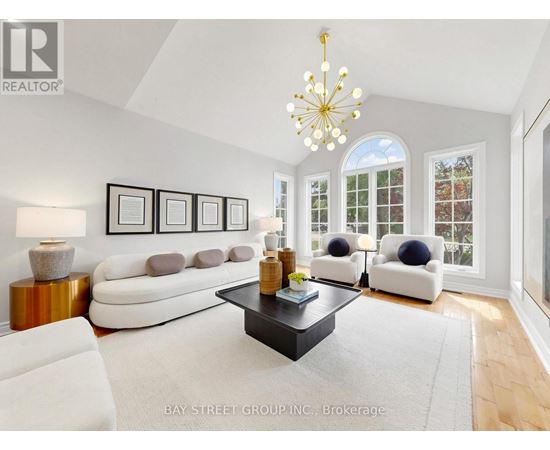 A living room with a white sofa, a coffee table, and a chandelier.