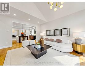 A living room with a white couch, a coffee table, and a chandelier.