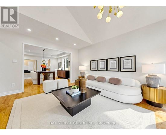 A living room with a white couch, a coffee table, and a chandelier.