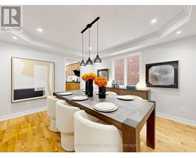A dining room with a wooden table and chairs.