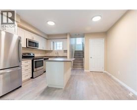 A kitchen with a refrigerator, microwave, and oven.