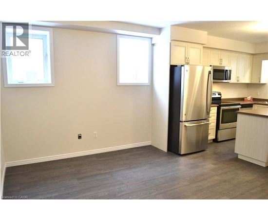 A kitchen with a refrigerator, microwave, and oven.