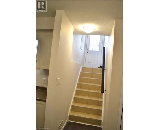A staircase with a light on the wall above it.