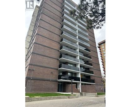 A tall brick building with balconies on the upper floors.
