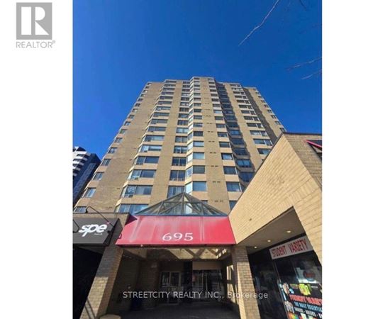 A tall building with a red awning and the number 695 on it.