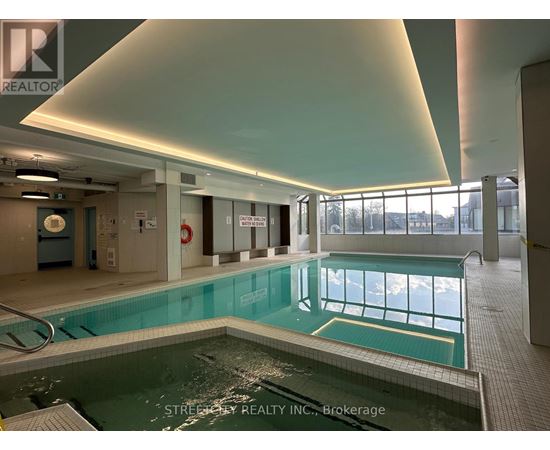 A large indoor swimming pool with a glass wall on one side.