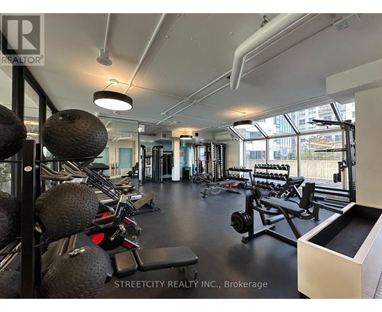 A gym with a variety of equipment including weights and weight machines.