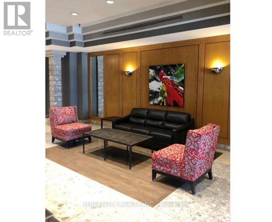 A living room with a black couch, two red patterned chairs, and a coffee table.