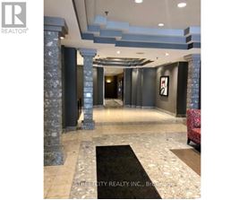 A hallway with a rug and pillars.