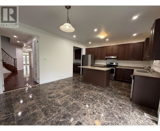 A kitchen with brown cabinets and a marble floor.