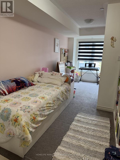 A bedroom with a floral bedspread and a rug on the floor.