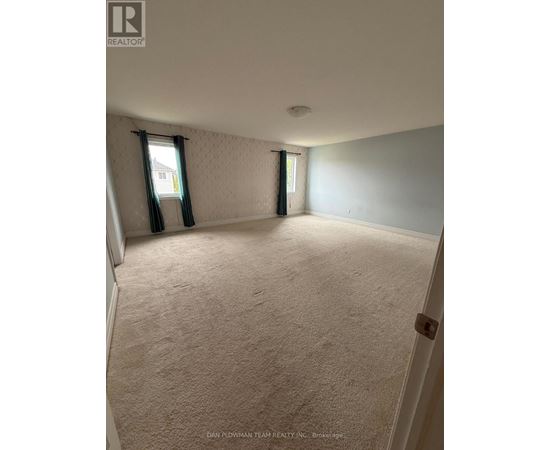 A room with a carpeted floor and a window with curtains.