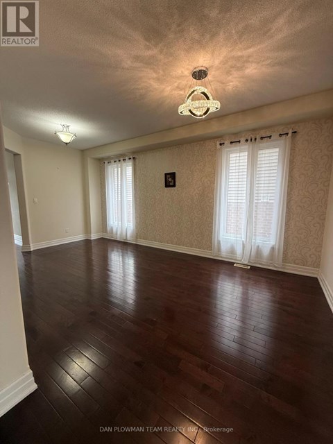 A room with wooden floors and a chandelier.