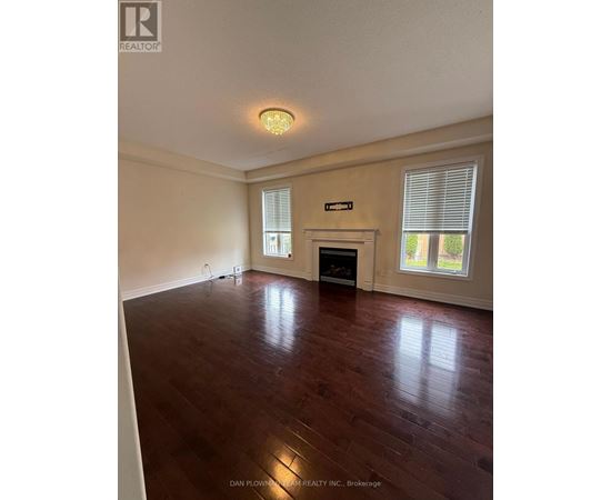 A room with a fireplace and wood flooring.