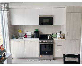 A kitchen with white cabinets and a black stove top.