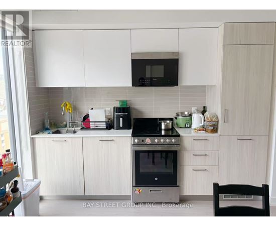 A kitchen with white cabinets and a black stove top.