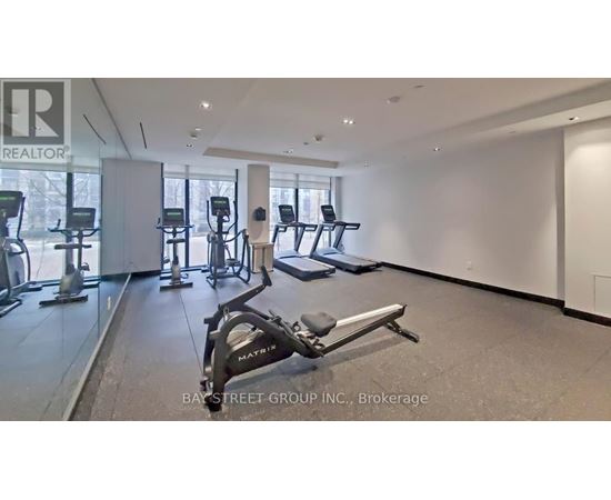 A gym with a variety of equipment including treadmills, stationary bikes, and weight machines.