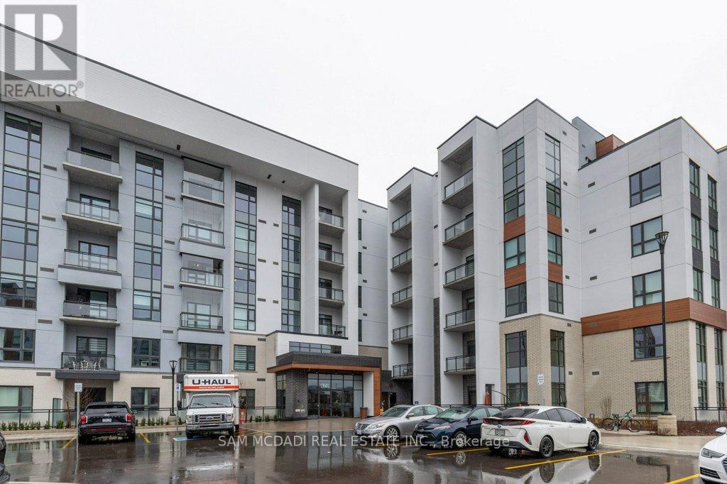 Apartment complex with cars parked in front.