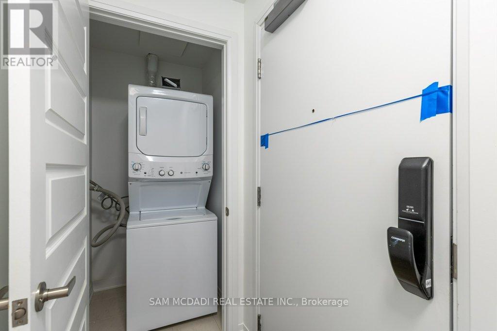 A white refrigerator is in a small kitchen with a door open.