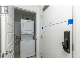 A white refrigerator is in a small kitchen with a door open.