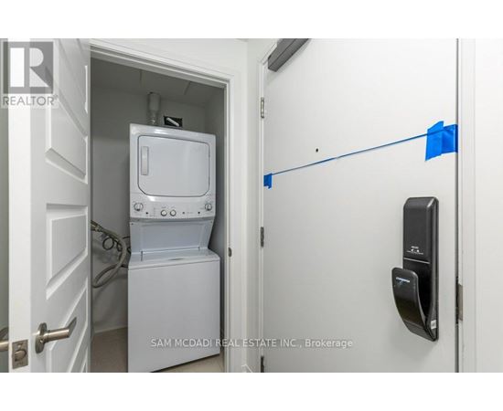 A white refrigerator is in a small kitchen with a door open.